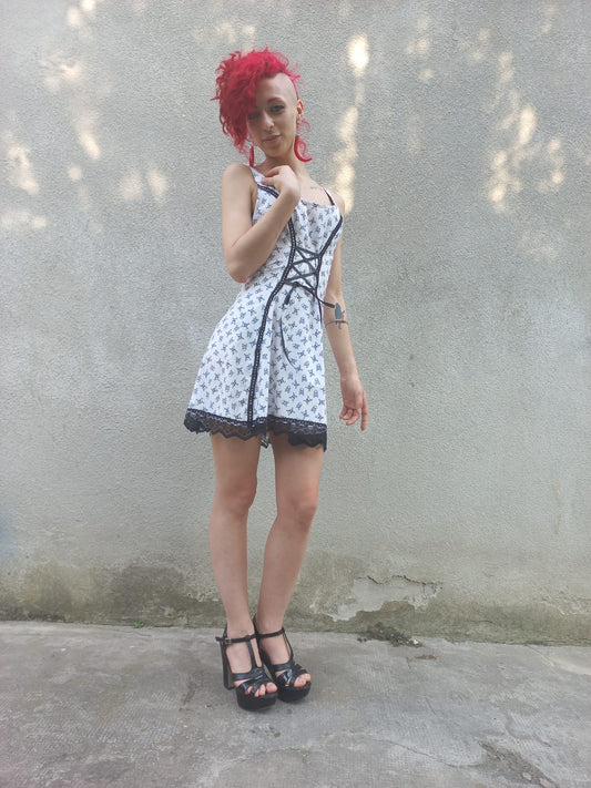 Miniabito in cotone bianco con pattern teschietti e dettagli in pizzo nero