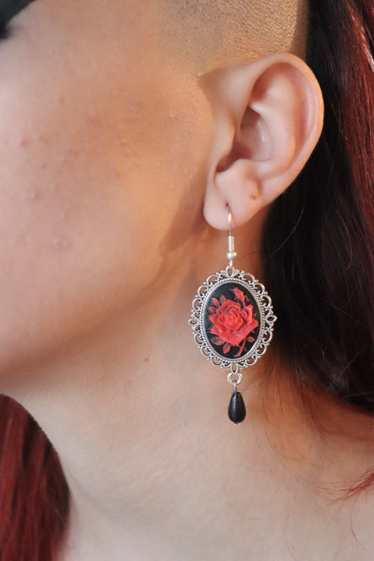 Pair of pendant earrings with red rose cameo on a black background